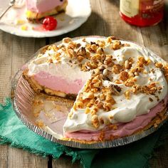 there is a pie with pink and white frosting on the top that has been cut in half