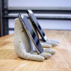 two cell phones sitting on top of each other in the shape of hands holding something