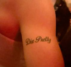 a person with a tattoo on their arm that says, die pulty in cursive writing