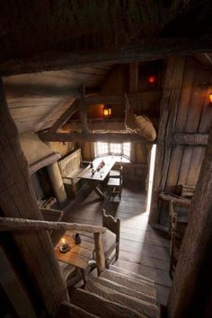 the interior of an old log cabin with wood floors and walls, along with wooden tables and chairs