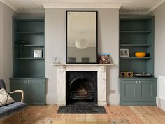 a living room filled with furniture and a fire place in the middle of a wooden floor