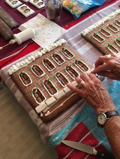 an older woman is decorating gingerbreads with icing