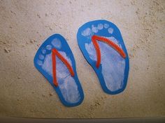 two pairs of flip flops with footprints painted on them