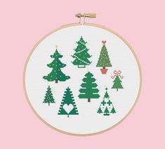 a cross stitch christmas tree pattern on a pink background