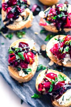 an assortment of appetizers on bread with cheese and vegetables in the middle, ready to be eaten