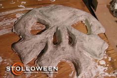 a wooden table topped with white paint and a skull shaped object on top of it