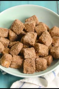 a white bowl filled with sugar cubes on top of a blue table