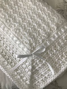 a white crocheted blanket on top of a bed