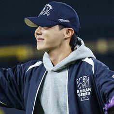 a young man wearing a baseball cap and gloves