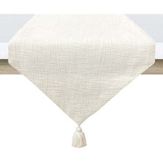 a white table runner with tassels on it