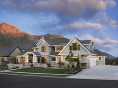 a large white house with mountains in the background