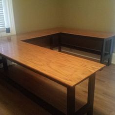 a wooden table sitting in the middle of a room with shutters on both sides