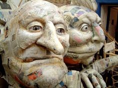 two faces made out of newspapers sitting next to each other