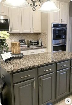 a kitchen with granite counter tops and white cabinets