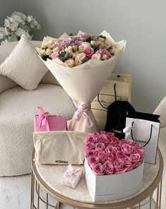 a bunch of flowers sitting on top of a table next to some boxes and bags