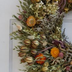 a wreath made out of dried flowers on a door