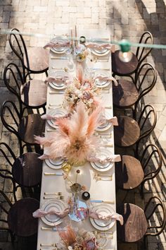 a long table is set with plates and chairs