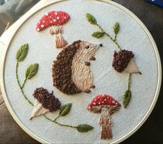 an embroidered hedge with mushrooms and leaves on it