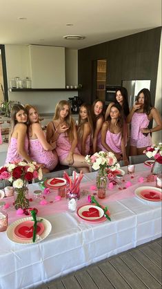 a group of women in pink dresses sitting at a table