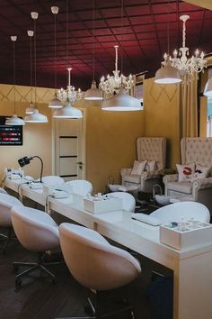 a salon with chairs and lights hanging from the ceiling