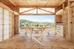 an open room with wooden walls and flooring that has sliding doors leading to the outside