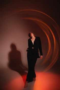 a woman standing in front of a circular light