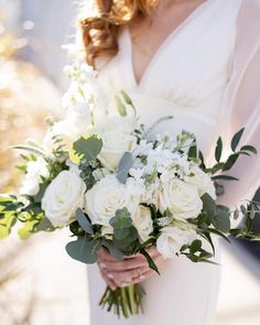 a bride holding a bouquet of white flowers