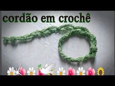 a green crochet bracelet with flowers and a white bird on it's side