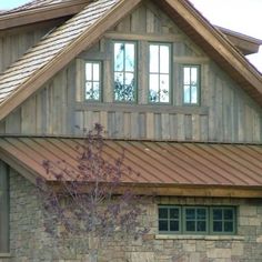 a stone house with a metal roof and windows