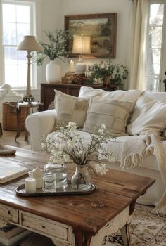 a living room filled with lots of furniture and flowers on top of a coffee table