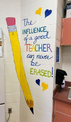 a yellow pencil painted on the side of a white wall in a school room with words written on it