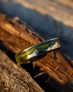 a green ring sitting on top of a piece of wood