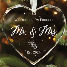 we decided on forever mr and mrs ornament hanging from a christmas tree with lights in the background