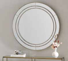 a round mirror on the wall above a console table