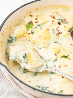 a spoon with some food in it on top of a pan filled with broccoli and cheese