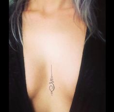 a close up of a woman's chest with a tattoo on her left side