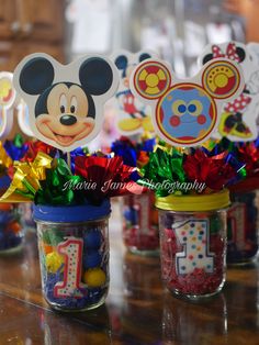 mickey mouse centerpieces in mason jars on a table