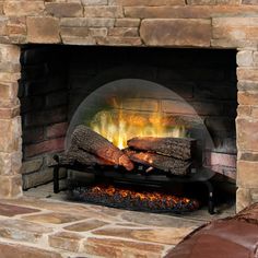 a stone fireplace with logs burning in it