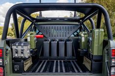 the back end of a green truck with its cargo compartment open