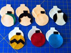 six felt ornaments are laid out on a blue cutting board and ready to be sewn