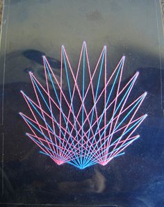 an abstract piece of art with pink and blue lines on black paper, in front of a dark background