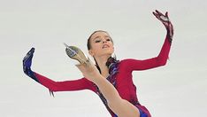 a female figure skating on ice with her arms in the air