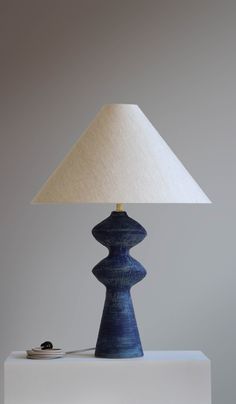 a blue lamp sitting on top of a table next to a white box with a button