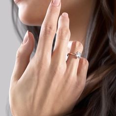 a close up of a person wearing a ring with a diamond on it's finger