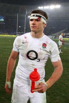 a rugby player holding a water bottle on the field