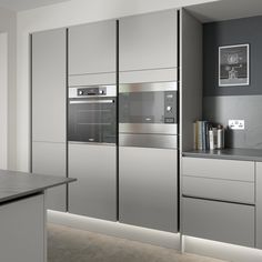 a modern kitchen with stainless steel appliances and white cabinets