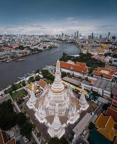 an aerial view of a large white building in the middle of a city with lots of tall buildings