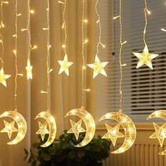 the stars and moon string lights are hanging from the ceiling in front of a window