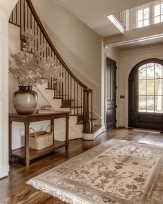 an entryway with a rug and vase on the floor