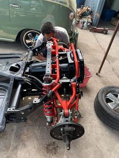 a man working on an engine in front of a car